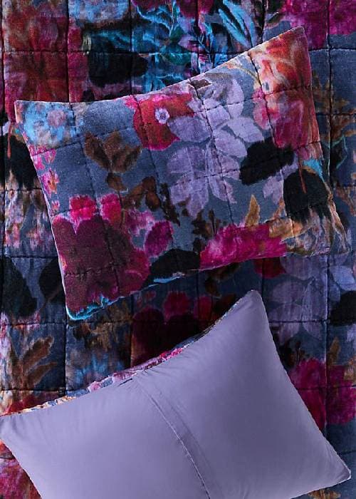 Velvet floral home furnishings in a winter living room, featuring textured velvet cushions and warm, soft lighting.