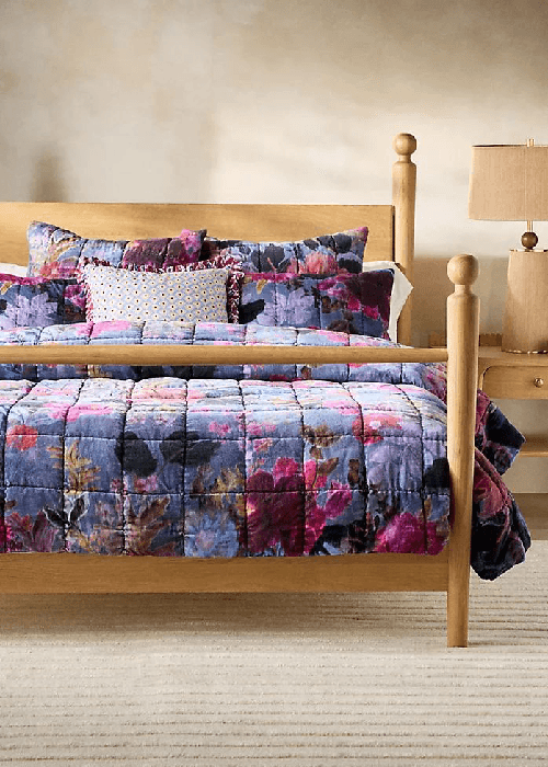 Velvet floral home furnishings in a winter living room, featuring textured velvet cushions and warm, soft lighting.
