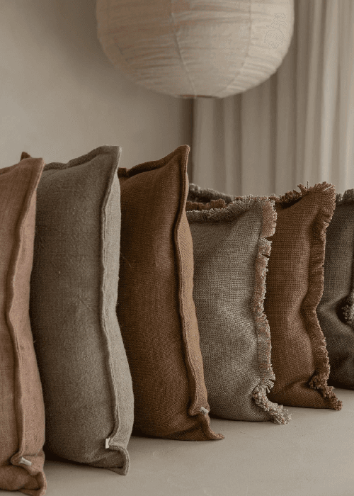 Washed linen and cotton home furnishings showing natural texture, breathable weave, and relaxed, lived-in surface for modern interiors.