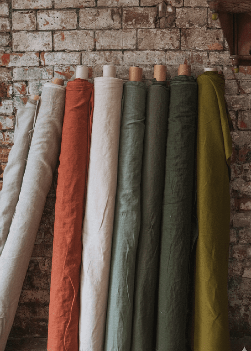 Washed linen and cotton home furnishings showing natural texture, breathable weave, and relaxed, lived-in surface for modern interiors.