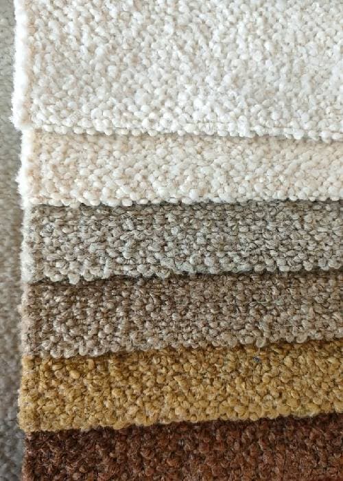 Close-up of bouclé and chenille upholstery fabric highlighting looped texture, soft pile, and tactile surface used in contemporary home furnishings.