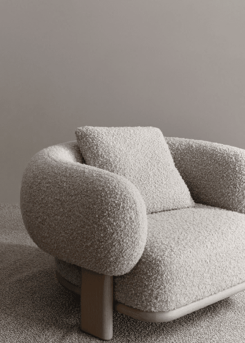 Close-up of bouclé and chenille upholstery fabric highlighting looped texture, soft pile, and tactile surface used in contemporary home furnishings.