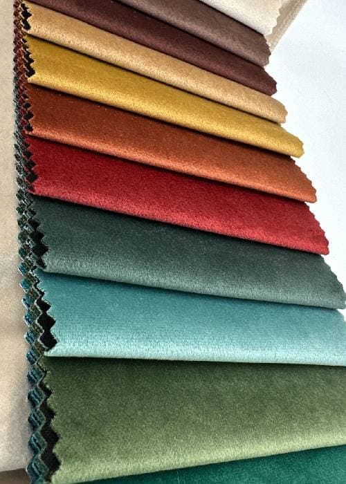 Plush velvet fabric in deep tones showing dense pile, soft texture, and light-responsive surface used in upholstery and soft furnishings.