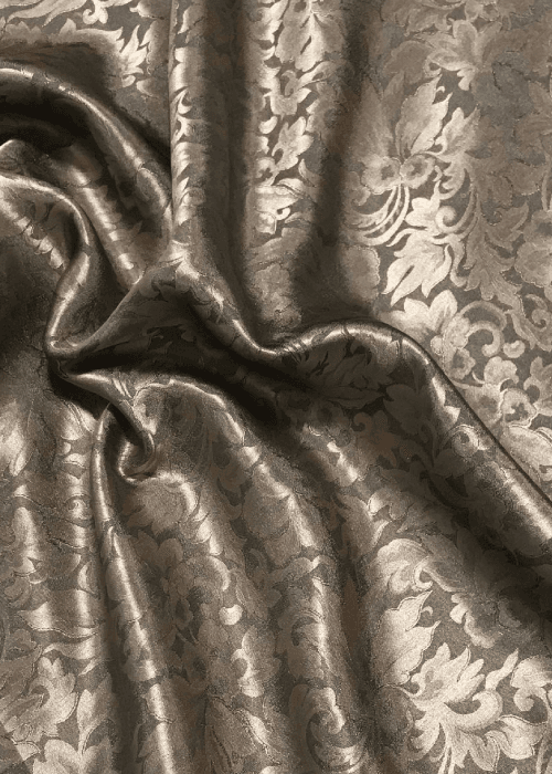 Detail of silk damask and jacquard fabric revealing intricate woven patterns, rich texture, and craftsmanship in luxury home textiles.